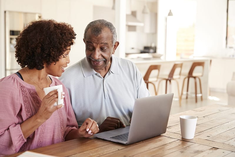 A father and daughter looking at a laptop together